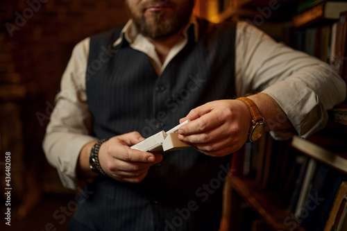 Bearded man holds pack of cigarettes, smoke habit