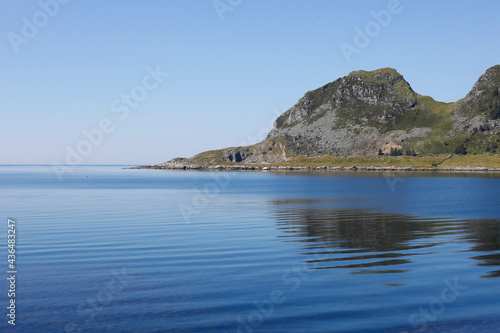 Nordic fjord, horizon over the ocean, island and mountain, clear blue sky