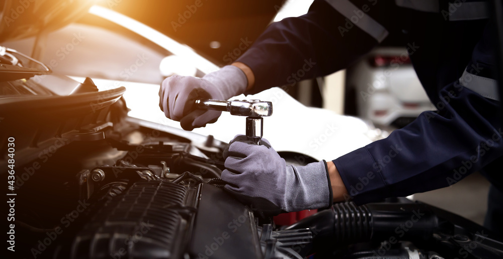 Auto mechanic working on car engine in mechanics garage.Repair service,car service, repair, maintenance concept. - obrazy, fototapety, plakaty 