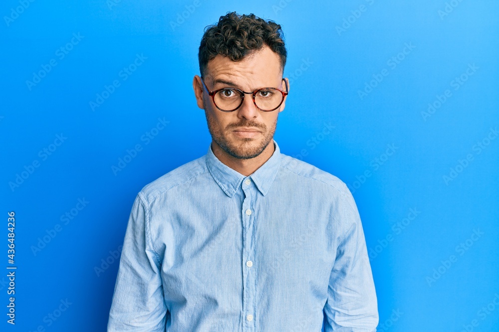 Young hispanic man wearing casual clothes and glasses skeptic and nervous, frowning upset because of problem. negative person. Young hispanic man wearing casual clothes and glasses skeptic and nervous, frowning upset because of problem. negative person.