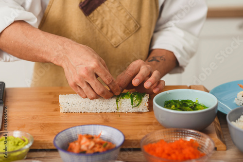 Close up process of preparing rolling sushi. Rolls with salmon fish and white rice 