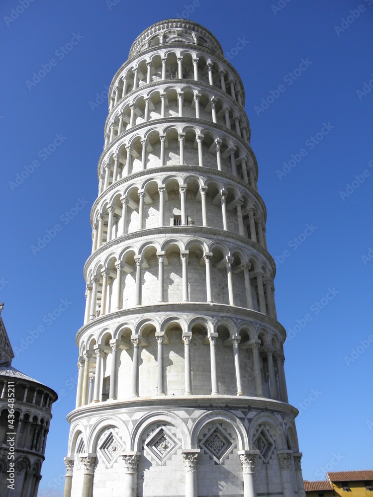 Leaning tower of Pisa, arches and columns from base to the top in the image, blue sky background.