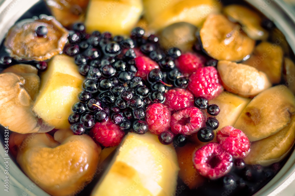 Casserole with fruits and berries. Cooking fruit and berry compote. Pear, apple, raspberry and black currant compote Casserole with fruits and berries. Cooking fruit and berry compote. Pear, apple, raspberry and black currant compote