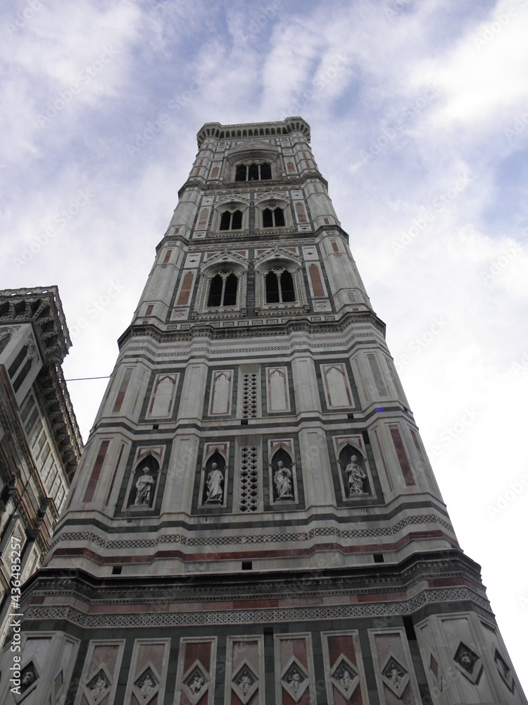 Bell tower of Santa Maria del Fiore. A tall building is a part of church, shot from the ground.