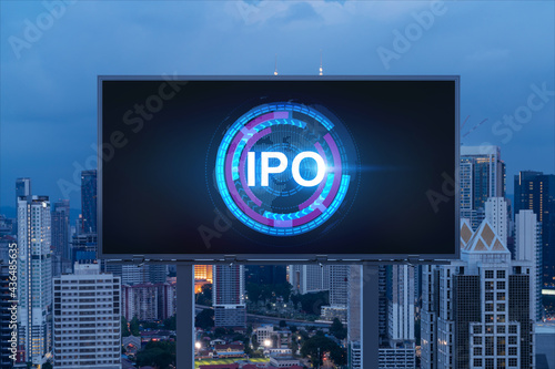 IPO icon hologram on road billboard over night panorama city view of Kuala Lumpur. KL is the hub of initial public offering in Malaysia, Asia. The concept of exceeding business opportunities.