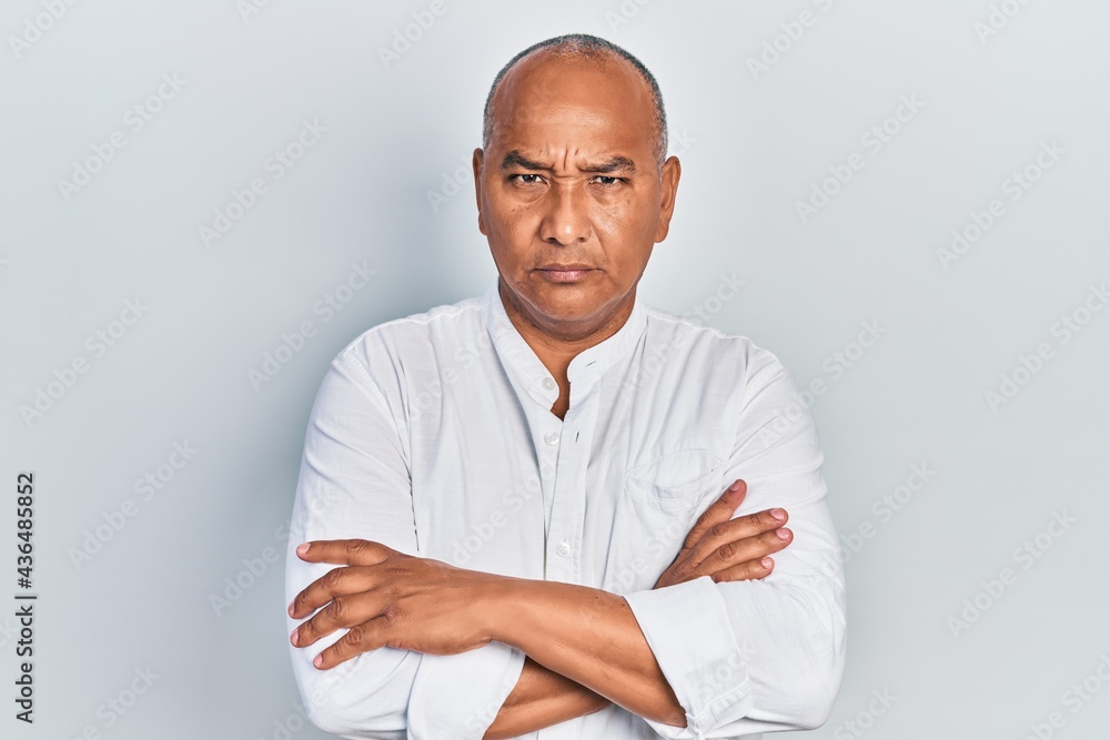 Middle age latin man wearing casual clothes skeptic and nervous, disapproving expression on face with crossed arms. negative person. Middle age latin man wearing casual clothes skeptic and nervous, disapproving expression on face with crossed arms. negative person.