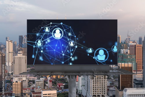 Glowing Social media icons on billboard over sunset panoramic city view of Kuala Lumpur, Malaysia, Asia. The concept of networking and establishing new connections between people and businesses in KL