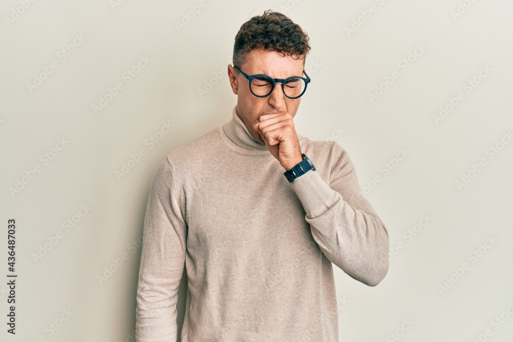 Hispanic young man wearing casual turtleneck sweater feeling unwell and coughing as symptom for cold or bronchitis. health care concept. Hispanic young man wearing casual turtleneck sweater feeling unwell and coughing as symptom for cold or bronchitis. health care concept.