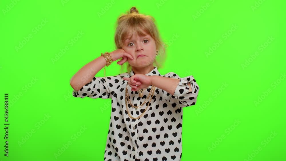 Hey you, call me back. Little cute blonde teen child kid girl in white black stylish shirt looking at camera doing phone gesture. Young children posing isolated on chroma key, green screen background Hey you, call me back. Little cute blonde teen child kid girl in white black stylish shirt looking at camera doing phone gesture. Young children posing isolated on chroma key, green screen background