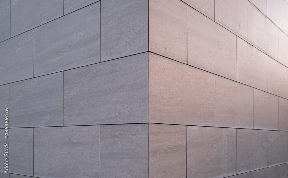 Obraz premium Abstract background of an office building made of stone and evening lights.