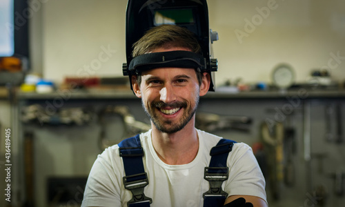 Close-up of the young welder with the welding mask. photo