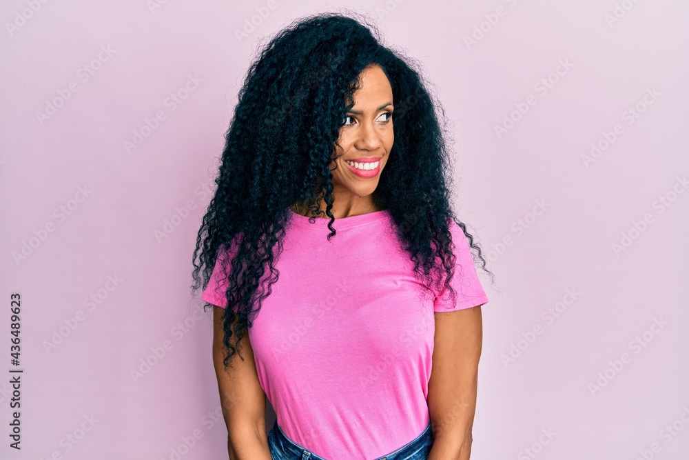 Middle age african american woman wearing casual clothes smiling looking to the side and staring away thinking. Middle age african american woman wearing casual clothes smiling looking to the side and staring away thinking.