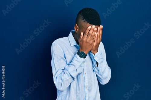 Young african american man wearing casual clothes with sad expression covering face with hands while crying. depression concept.