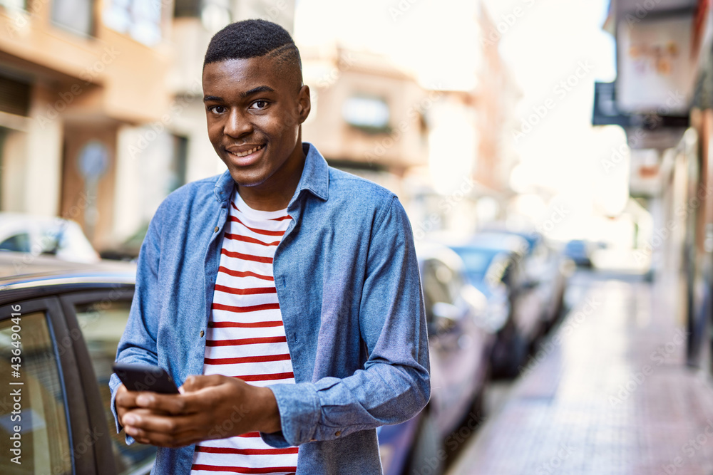 Young african american man smiling happy using smartphone at the city. Young african american man smiling happy using smartphone at the city.