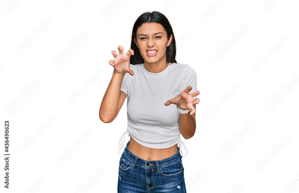 Young hispanic girl wearing casual white t shirt smiling funny doing claw gesture as cat, aggressive and sexy expression Young hispanic girl wearing casual white t shirt smiling funny doing claw gesture as cat, aggressive and sexy expression