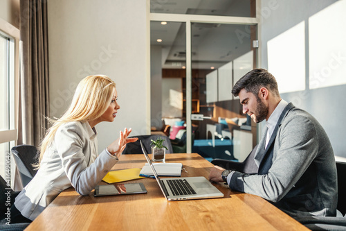 Tableau sur toile Angry bossy woman in fashion elegance suit yelling at her work colleague while sitting in an office with technology and office supplies such as a laptop,digital tablet, notebook