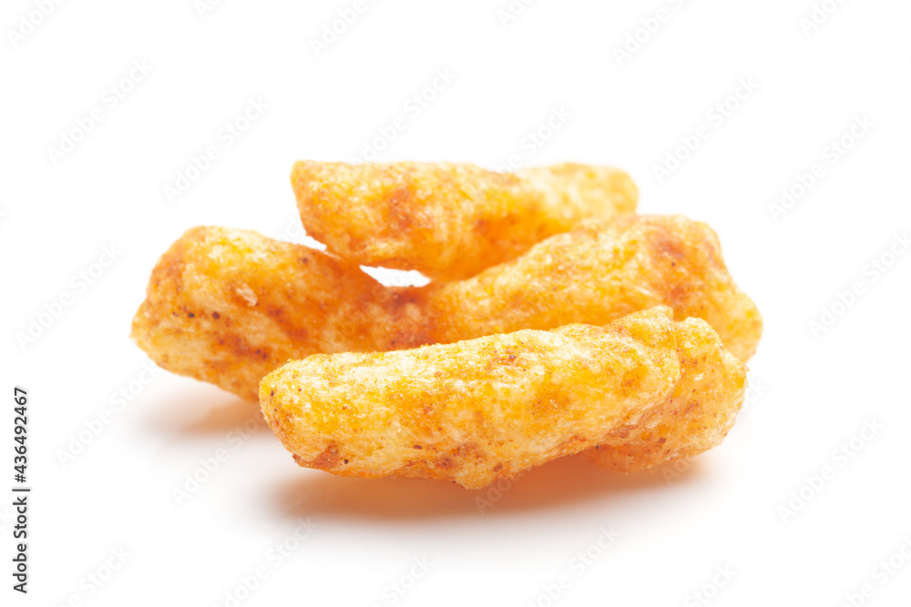 Close up of tangy Potato Puff Snacks sticks, Popular Ready to eat crunchy and puffed snacks sticks tangy spicy orange color over white background Close up of tangy Potato Puff Snacks sticks, Popular Ready to eat crunchy and puffed snacks sticks tangy spicy orange color over white background