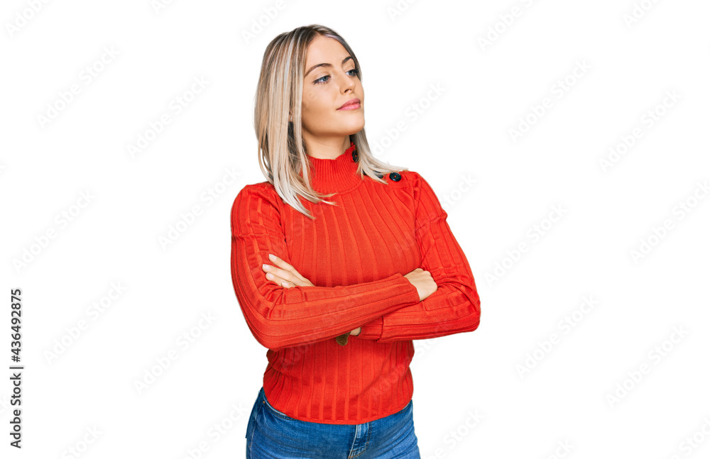 Beautiful blonde woman wearing casual clothes looking to the side with arms crossed convinced and confident Beautiful blonde woman wearing casual clothes looking to the side with arms crossed convinced and confident