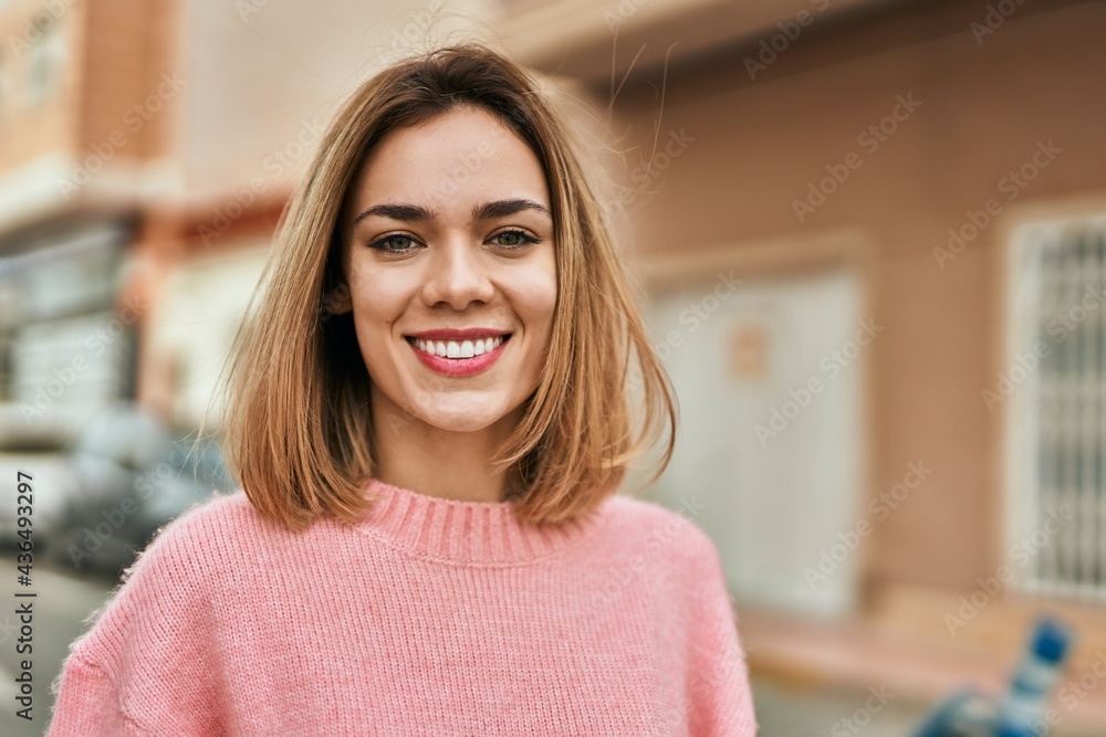 Young caucasian girl smiling happy standing at the city.