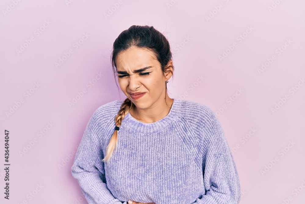 Young hispanic girl wearing casual clothes with hand on stomach because nausea, painful disease feeling unwell. ache concept. Young hispanic girl wearing casual clothes with hand on stomach because nausea, painful disease feeling unwell. ache concept.