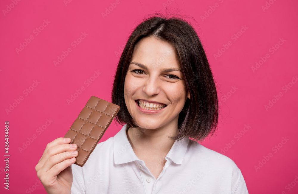 Beautiful young woman holding a bar of chocolate in her hand Beautiful young woman holding a bar of chocolate in her hand