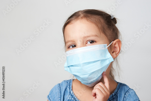 Little girl wearing face mask on a white background