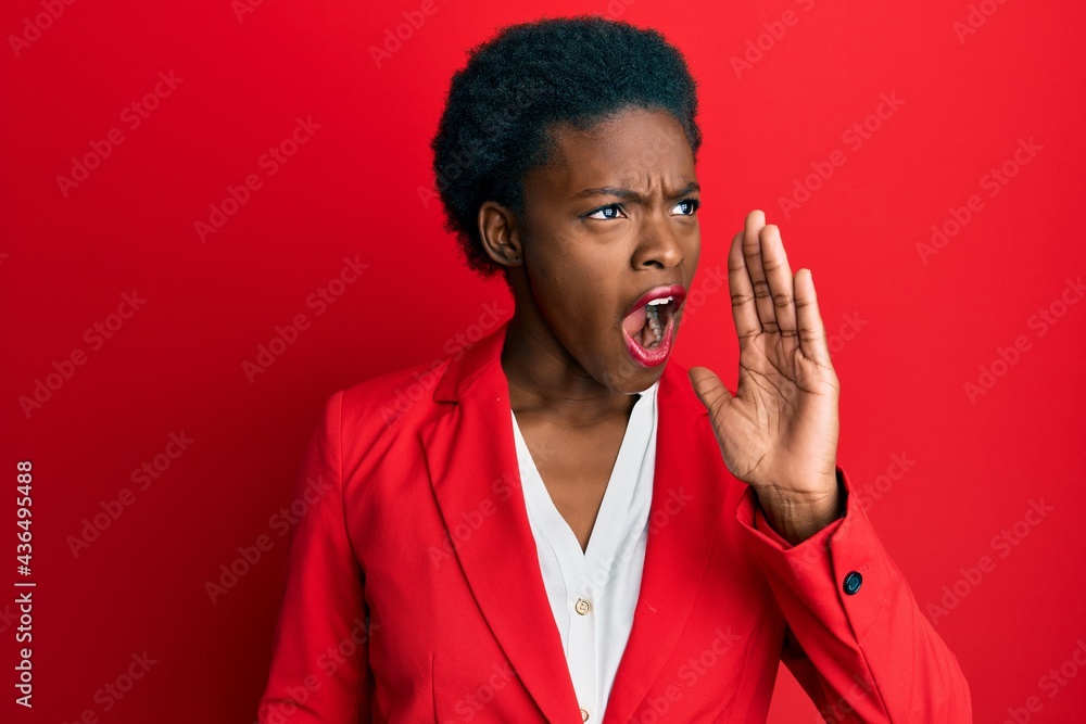 Young african american girl wearing business clothes shouting and screaming loud to side with hand on mouth. communication concept. Young african american girl wearing business clothes shouting and screaming loud to side with hand on mouth. communication concept.