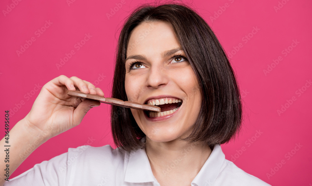 Beautiful young woman bites a bar of chocolate. Beautiful young woman bites a bar of chocolate.
