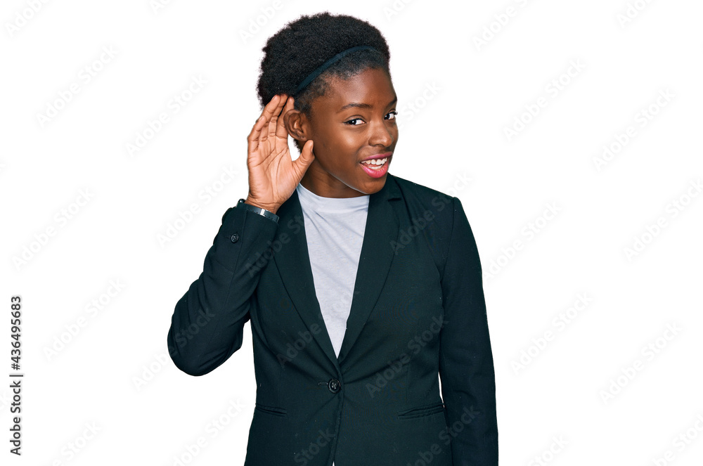 Young african american girl wearing business clothes smiling with hand over ear listening an hearing to rumor or gossip. deafness concept. Young african american girl wearing business clothes smiling with hand over ear listening an hearing to rumor or gossip. deafness concept.
