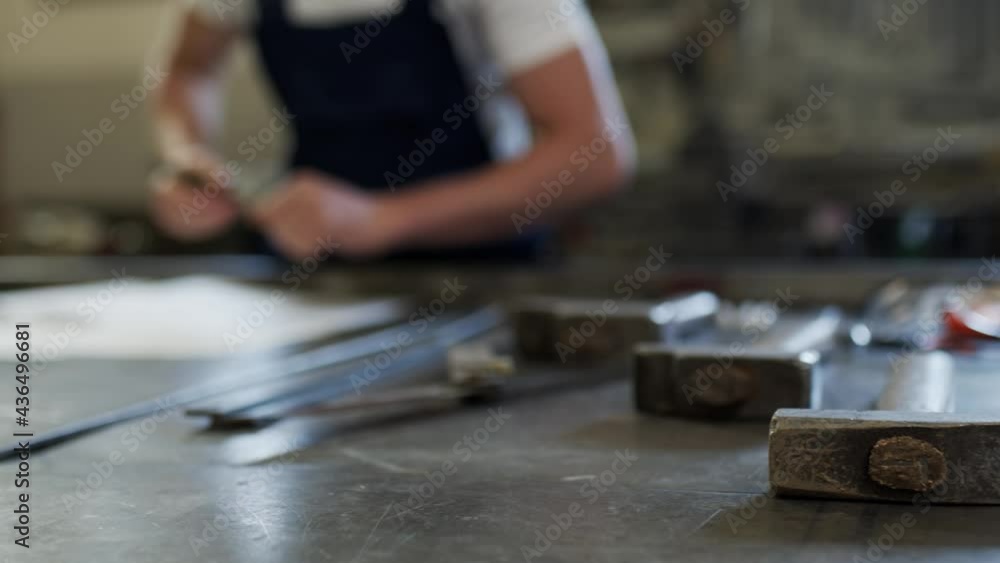 The craftsman prepares the work in the workshop.ruler, hammer, iron The craftsman prepares the work in the workshop.ruler, hammer, iron