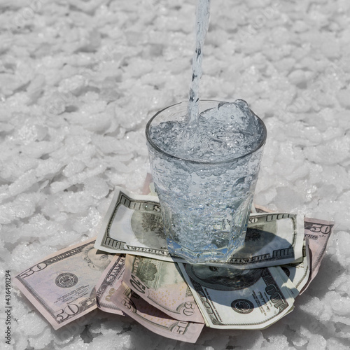 the glass is on dollars and on large pieces of salt, drinking water is poured into it