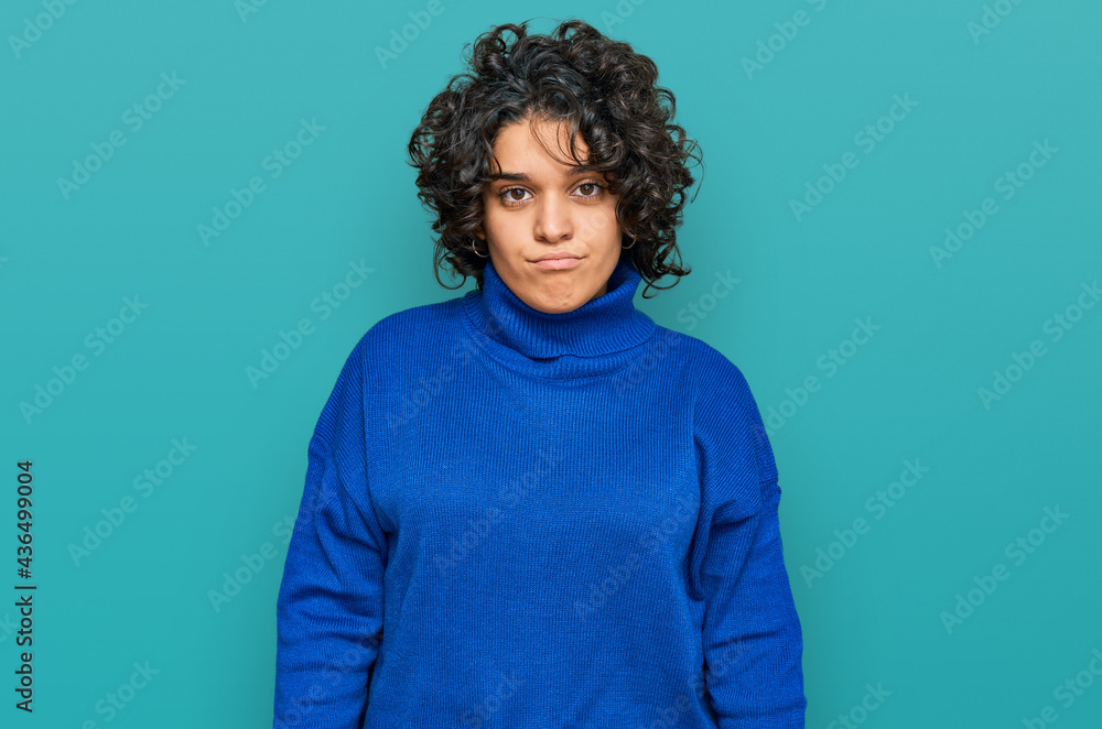Young hispanic woman with curly hair wearing turtleneck sweater looking sleepy and tired, exhausted for fatigue and hangover, lazy eyes in the morning. Young hispanic woman with curly hair wearing turtleneck sweater looking sleepy and tired, exhausted for fatigue and hangover, lazy eyes in the morning.