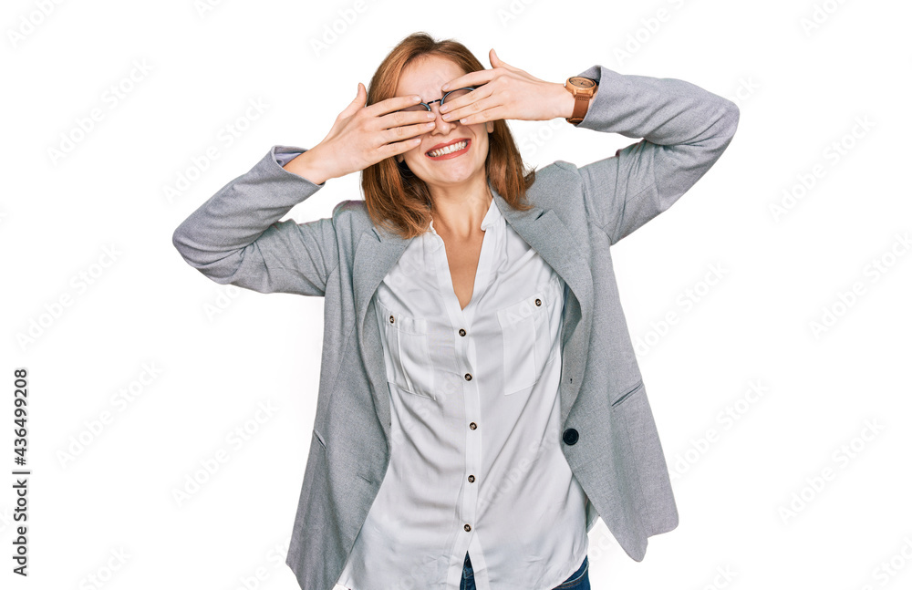 Young caucasian woman wearing business style and glasses covering eyes with hands smiling cheerful and funny. blind concept. Young caucasian woman wearing business style and glasses covering eyes with hands smiling cheerful and funny. blind concept.