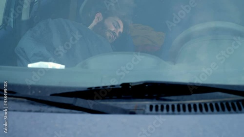 covi19 - young man sleeps in the car after losing his job photo