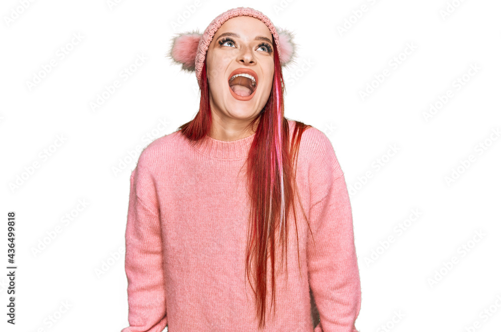 Young caucasian woman wearing casual clothes and wool cap angry and mad screaming frustrated and furious, shouting with anger. rage and aggressive concept. Young caucasian woman wearing casual clothes and wool cap angry and mad screaming frustrated and furious, shouting with anger. rage and aggressive concept.