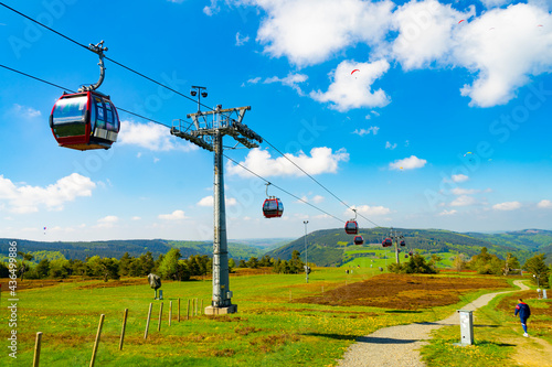 A cabin cable car travels up a green mountain - Willingen, Sauerland