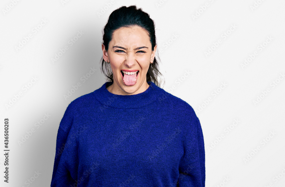 Fototapeta premium Young hispanic woman wearing casual clothes sticking tongue out happy with funny expression. emotion concept.