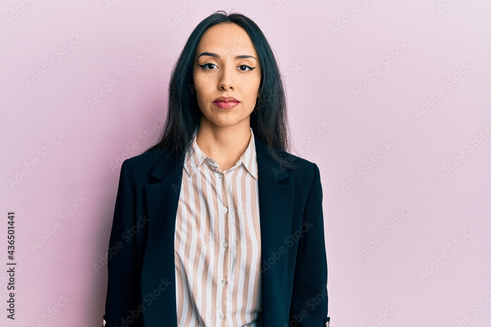 Young hispanic girl wearing business clothes relaxed with serious expression on face. simple and natural looking at the camera. Young hispanic girl wearing business clothes relaxed with serious expression on face. simple and natural looking at the camera.