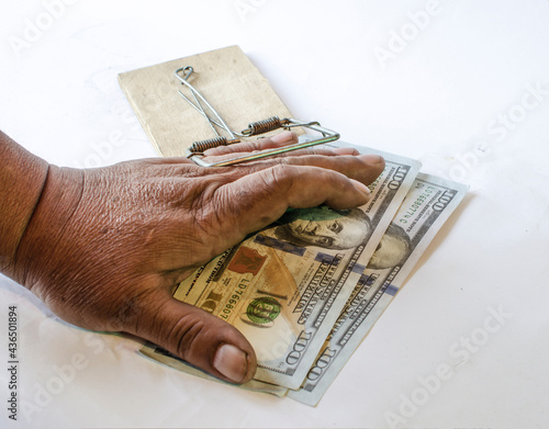 The hand of a bribe taker on a mousetrap with money. photo