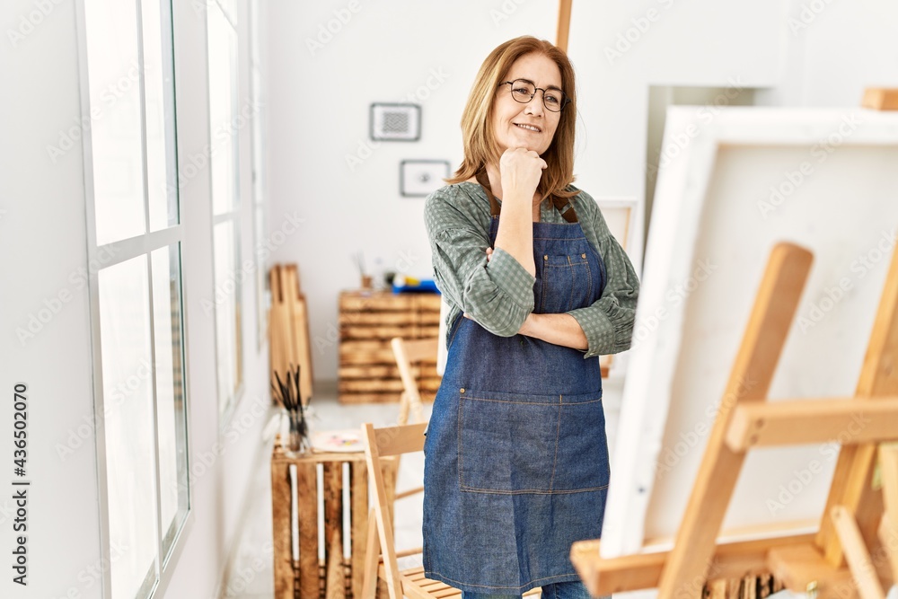 Middle age artist woman smiling happy painting at art studio. Middle age artist woman smiling happy painting at art studio.