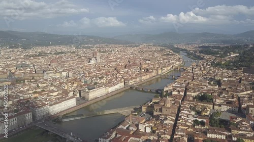 drone flying froward above the florence roofs, rivers and bridges with panoramic view