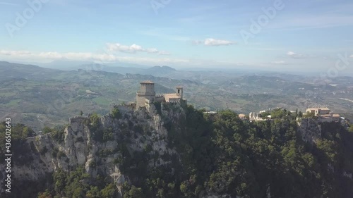 drone flying back from san marino towers at the top of the mountain  in Italy