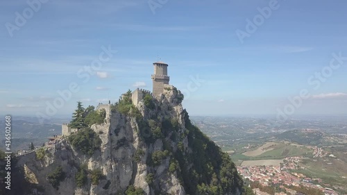 drone flying panoramic right around the san marino towers at the top of the mountain in Italy view from down