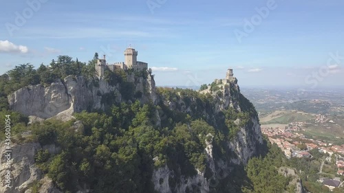 drone flying froward up and panoramic right around the san marino towers at the top of the mountain  in Italy