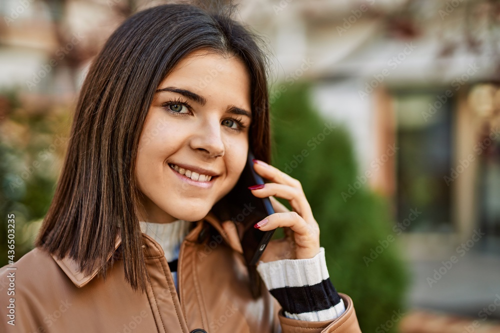 Young beautiful brunette woman smiling happy outdoors speaking on the phone Young beautiful brunette woman smiling happy outdoors speaking on the phone