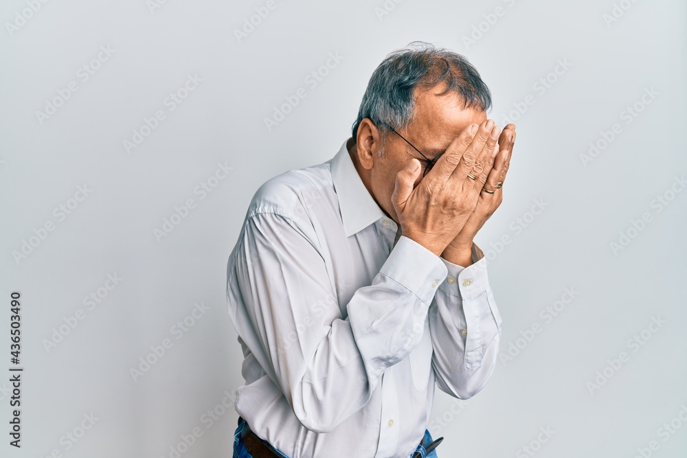 Middle age indian man wearing casual clothes and glasses with sad expression covering face with hands while crying. depression concept. Middle age indian man wearing casual clothes and glasses with sad expression covering face with hands while crying. depression concept.