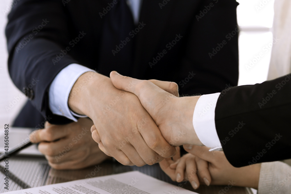 Business people shaking hands after contract signing in modern office. Teamwork, partnership and handshake concept Business people shaking hands after contract signing in modern office. Teamwork, partnership and handshake concept