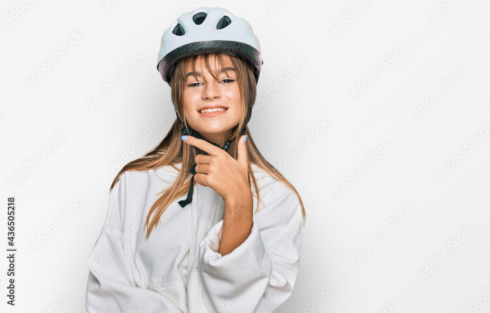 Teenager caucasian girl wearing bike helmet looking confident at the camera smiling with crossed arms and hand raised on chin. thinking positive. Teenager caucasian girl wearing bike helmet looking confident at the camera smiling with crossed arms and hand raised on chin. thinking positive.