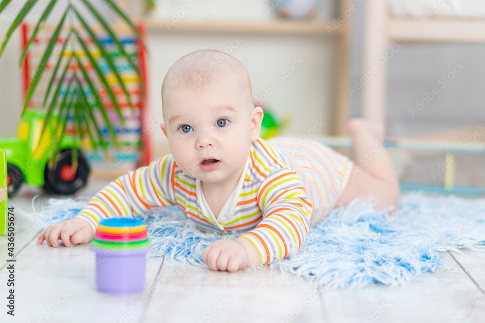 baby boy among the toys in the children's room, cute funny smiling little baby playing on the floor, the concept of children's development and games baby boy among the toys in the children's room, cute funny smiling little baby playing on the floor, the concept of children's development and games
