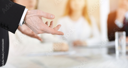 Business presentation. Businessman giving speech to colleagues and partners at corporate meeting or conference, close-up of speaker hands